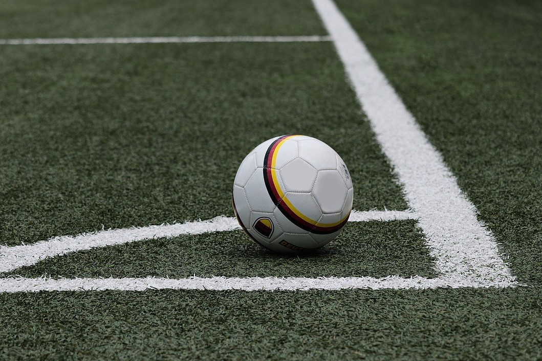 Ein Fußball liegt in einer Ecke eines Fußballfelds.