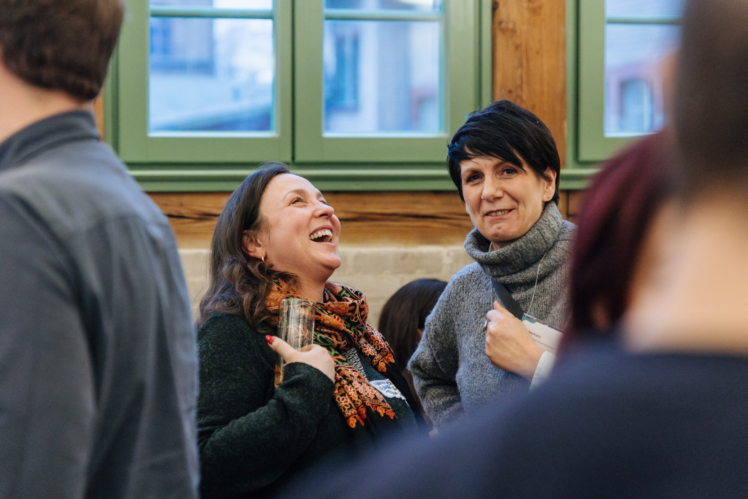 Zwei Frauen unterhalten sich und lachen herzlich.